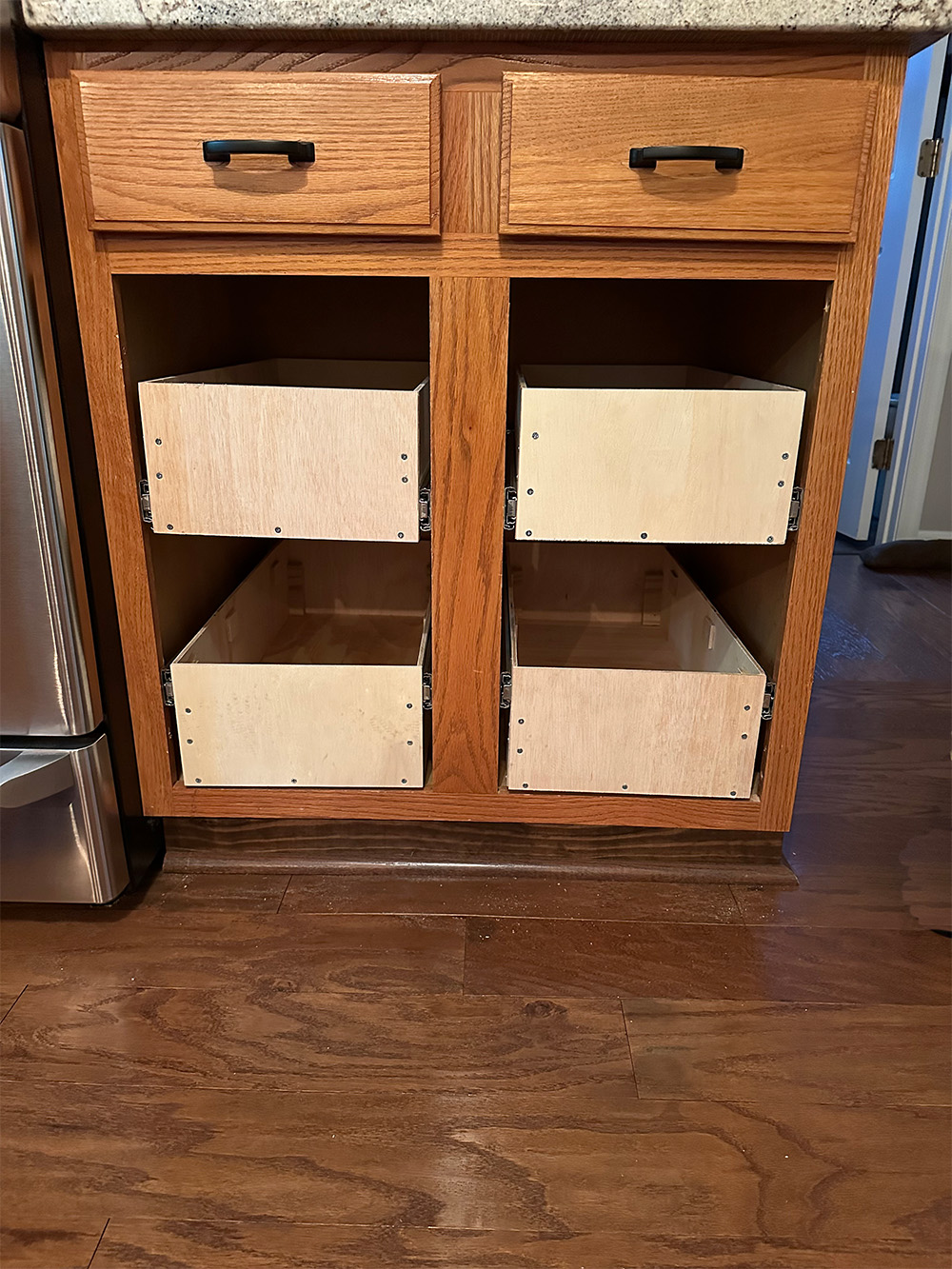 During- Kitchen cabinets with doors off, two lower drawers and two upper drawers installed